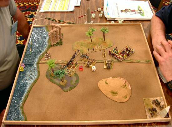 Mike Gunn (barely visible at left) of Roseburg, Oregon, with his 15mm Assyrians, left, top and right, after fully enveloping Don Ray's Sumerians, in the final, championship round to win the Hot Wheels DBA tourney. -  Armies by Denny Hartung and Paul Hannah of Seattle; terrain and photo by Paul Hannah