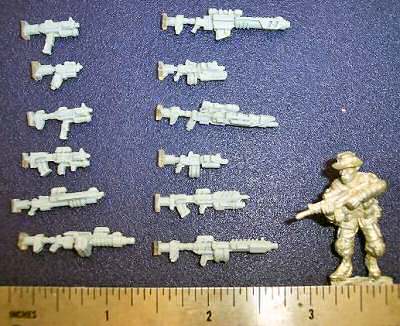 A dozen new weapon prototypes shown with a 28mm figure for scale