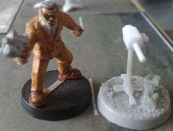 Unpainted base defense gun, with figure for size comparison; base from Dark Art Miniatures