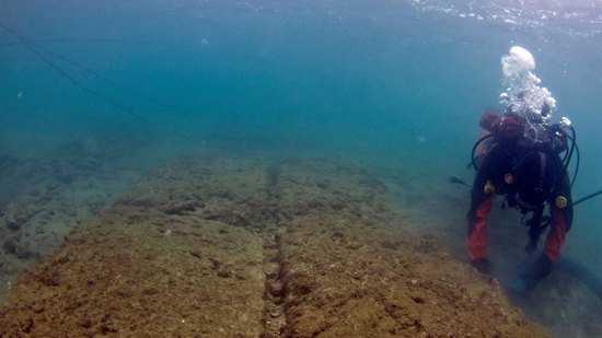 An underwater archaeologist excavates remains of a ship shed at Mounichia Harbor, during a rare period of good visibility.