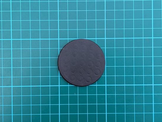 Single round black 50mm plastic base on gridded background