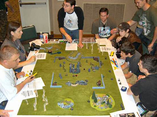 Game designer Matt Hope, center, hosts an AE World War II/Pulp City cross-over event. The Allies (left) must defend a temple from the Germans (right)